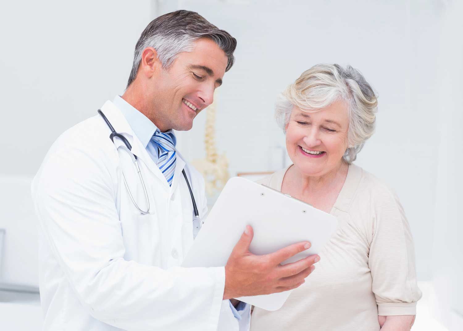 A woman sits on an exam table and talks to a nurse