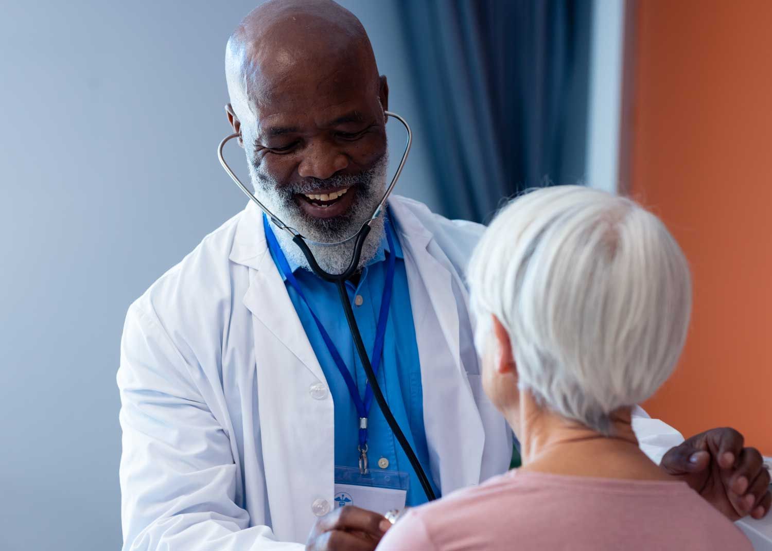 A woman sits on an exam table and talks to a nurse